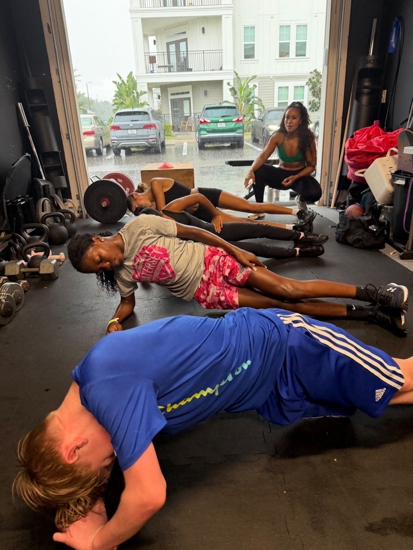Young athletes stretching on the floor with their coach at a kids bootcamp